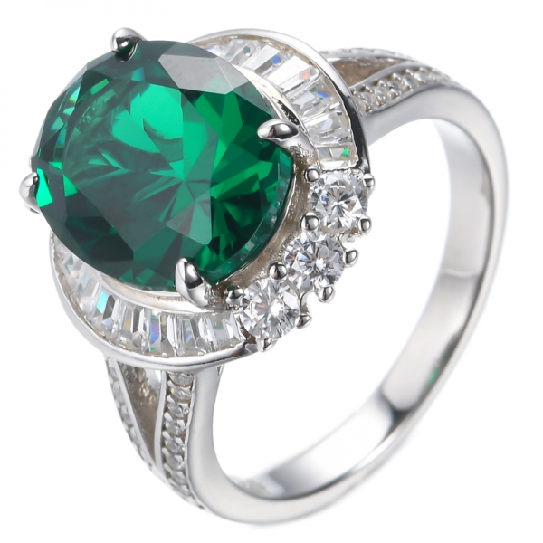 Ring aus ovalem Smaragd in der Mitte und rhodiniertem Silber mit weißem Baguette
 